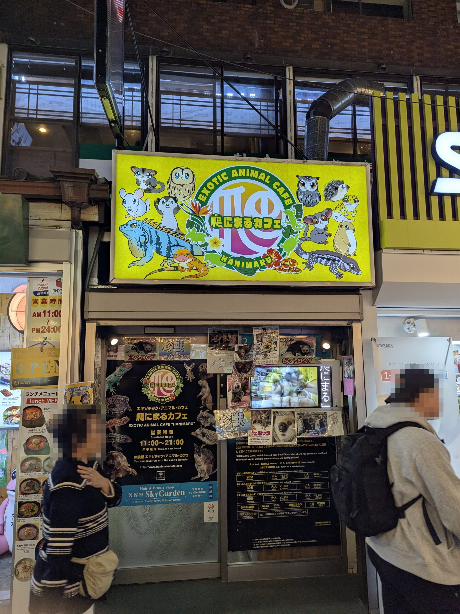 爬にまるカフェの店舗外観。黄色い看板にエキゾチックアニマルのイラストが描かれている